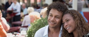 Mixed race couple hugging in sidewalk cafe